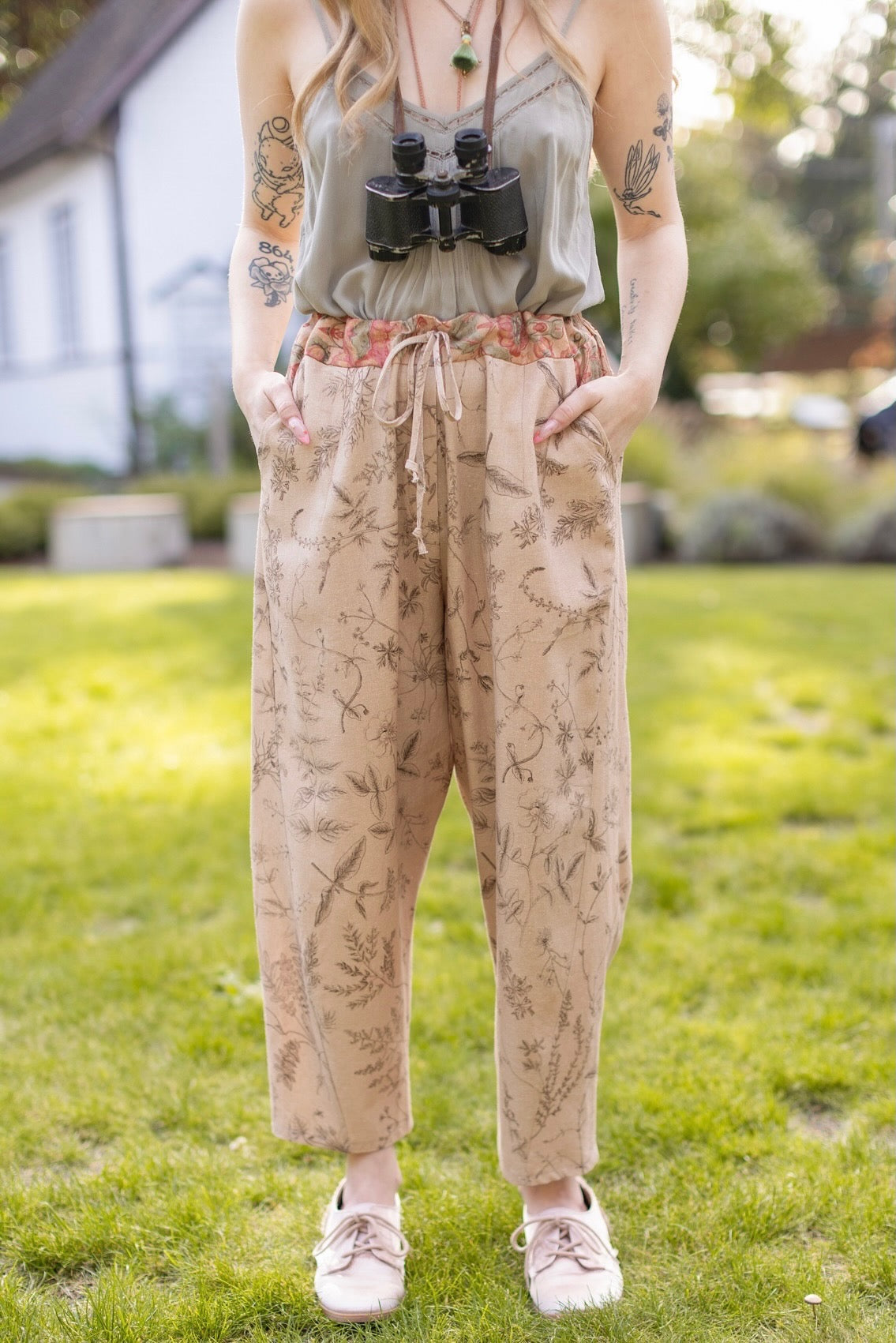Model wearing artist pants in oat featuring reimagined vintage 1846 map of a woman’s heart with playful updated place names – Market of Stars