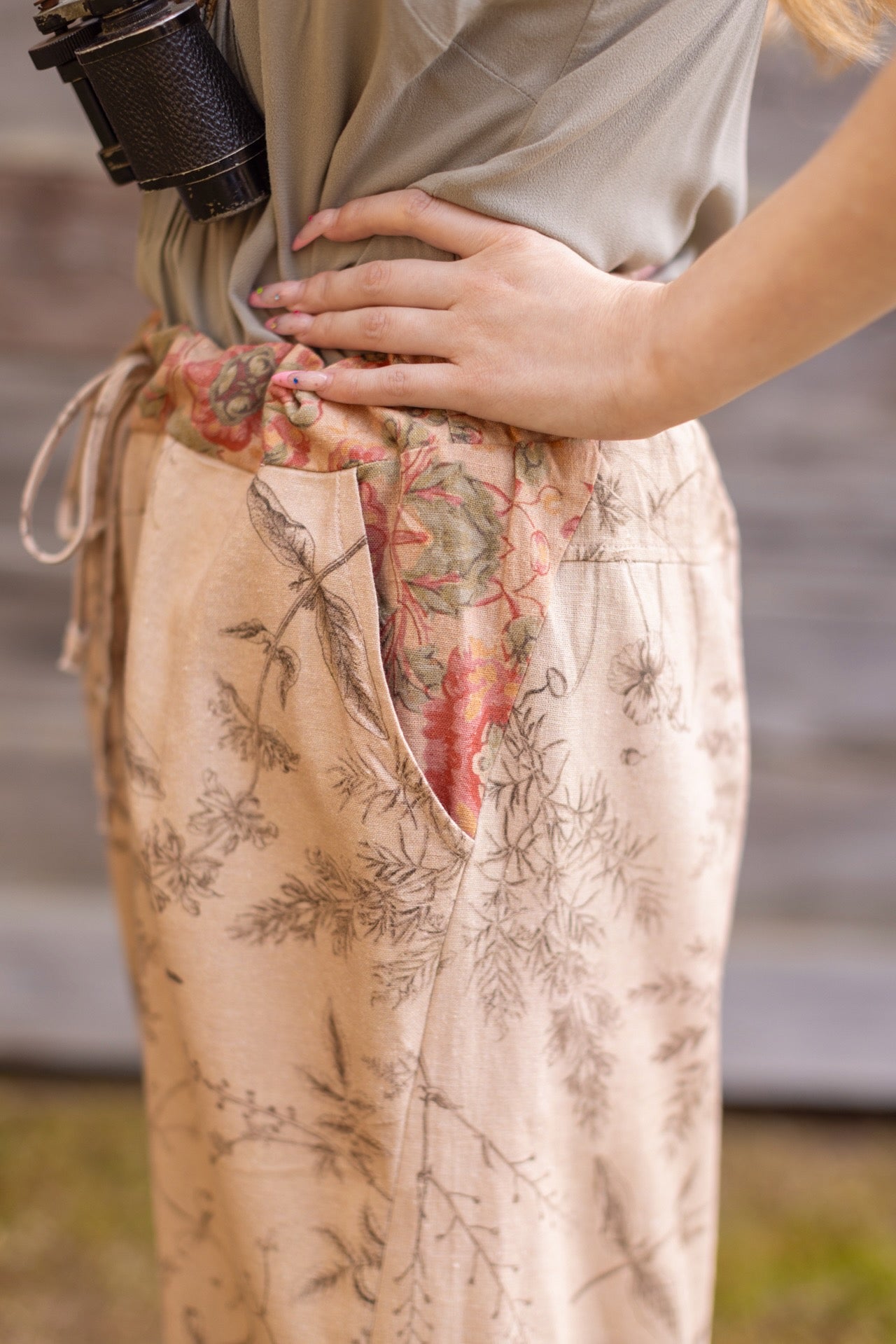 Model wearing artist pants in oat featuring reimagined vintage 1846 map of a woman’s heart with playful updated place names – Market of Stars