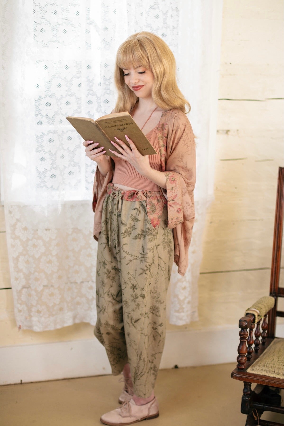 Model wearing artist pants in sage featuring reimagined vintage 1846 map of a woman’s heart with playful updated place names – Market of Stars
