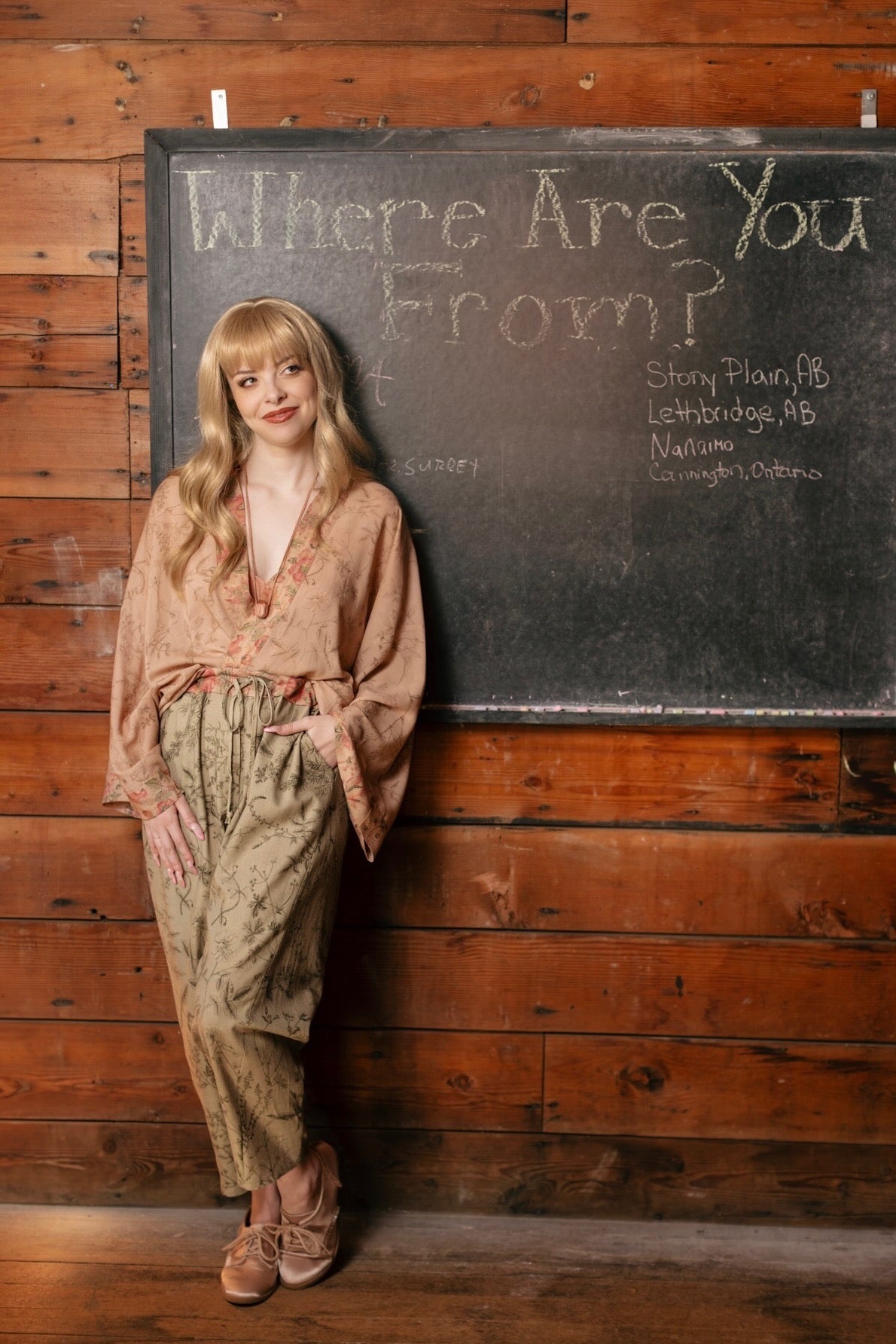 Model wearing artist pants in sage featuring reimagined vintage 1846 map of a woman’s heart with playful updated place names – Market of Stars