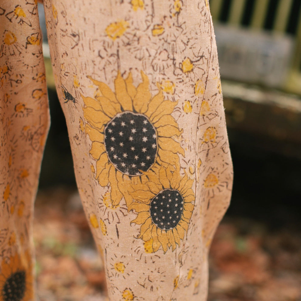
                  
                    Model wearing the Milk & Honey Artist Pants featuring playful 1904 Brooklyn poster art and antique woodcut star and floral details in vintage-inspired tones – Market of Stars.
                  
                