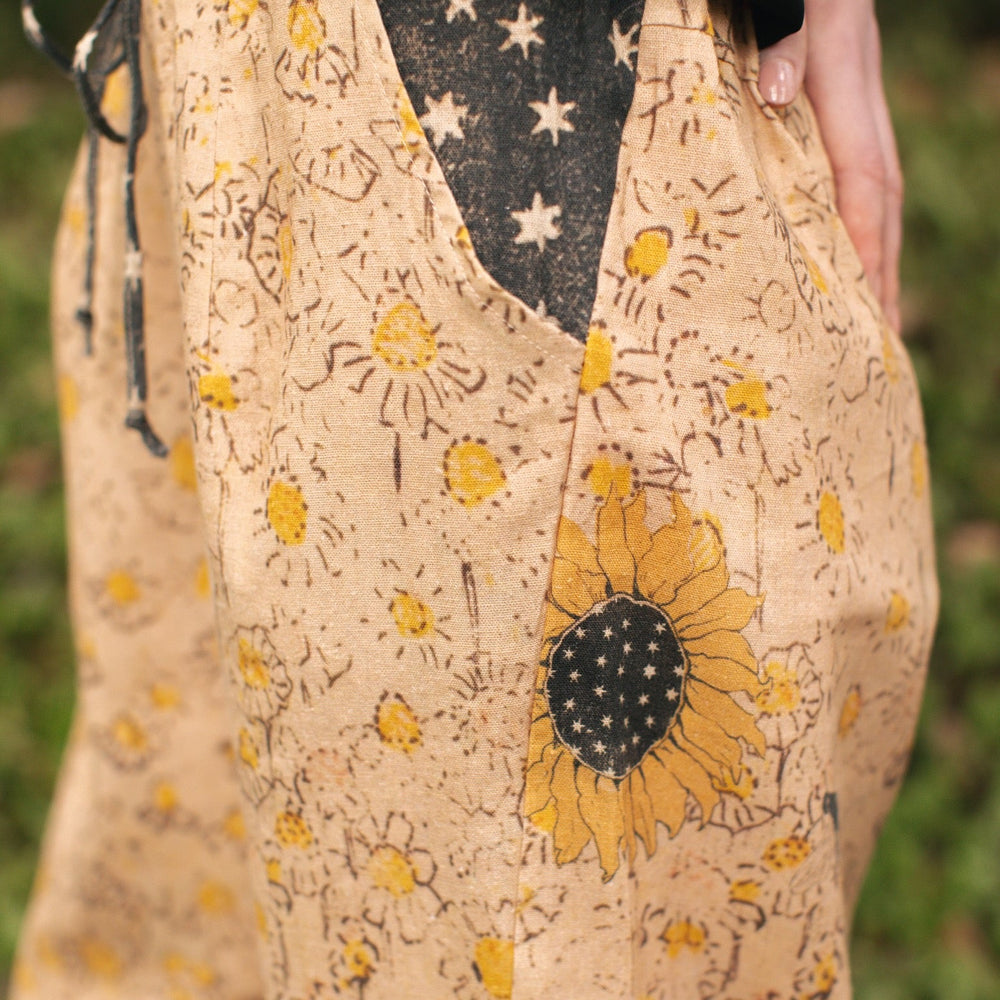 
                  
                    Model wearing the Milk & Honey Artist Pants featuring playful 1904 Brooklyn poster art and antique woodcut star and floral details in vintage-inspired tones – Market of Stars.
                  
                