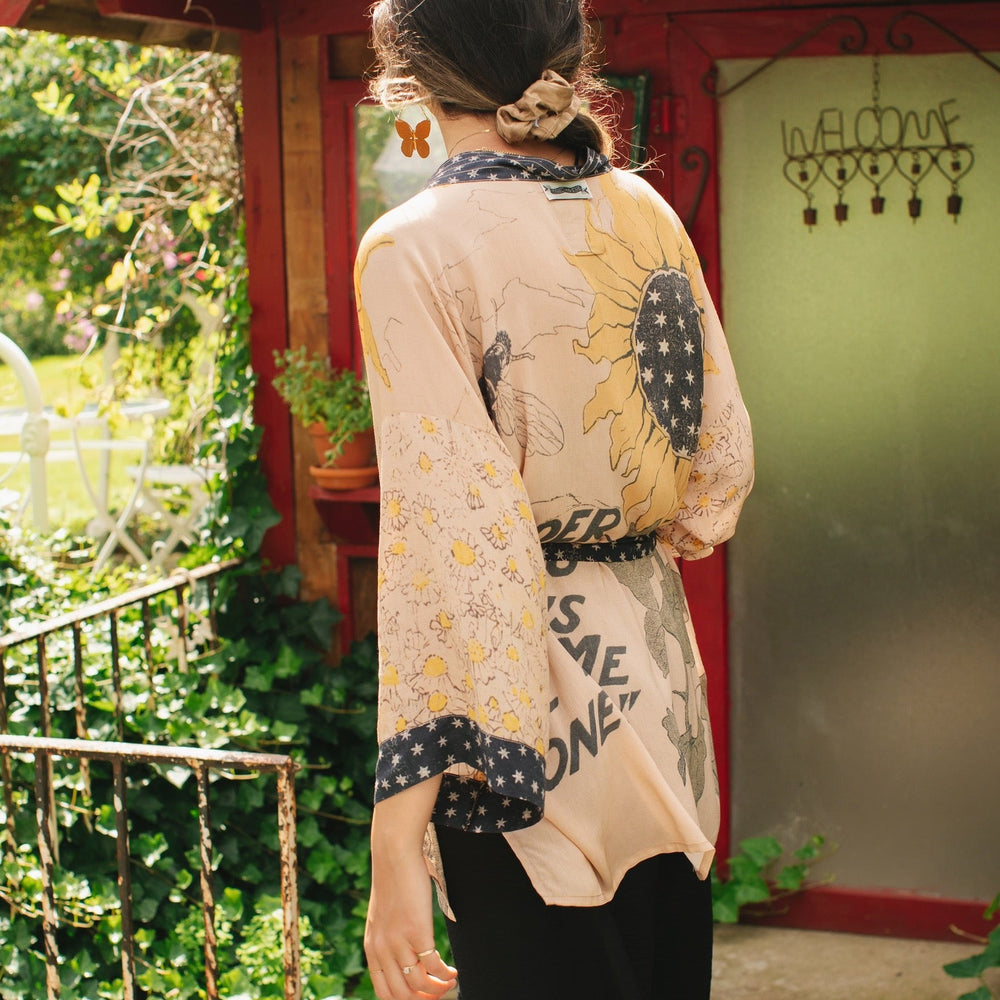 
                  
                    Model wearing our matinee length kimono featuring vintage-inspired Milk & Honey print with 1904 typography and floral woodcuts – Market of Stars
                  
                