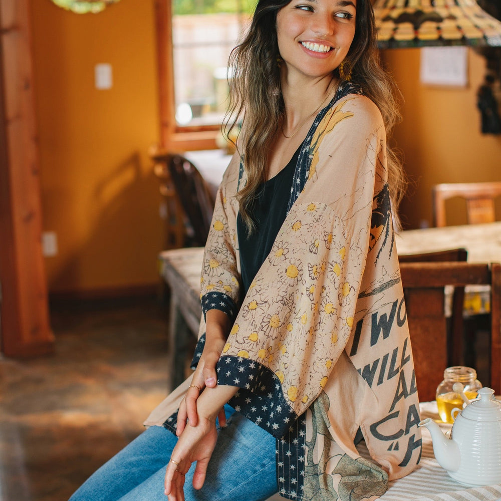 
                  
                    Model wearing our matinee length kimono featuring vintage-inspired Milk & Honey print with 1904 typography and floral woodcuts – Market of Stars
                  
                