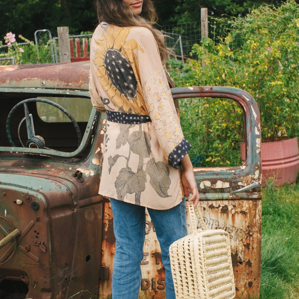 
                  
                    Model wearing our matinee length kimono featuring vintage-inspired Milk & Honey print with 1904 typography and floral woodcuts – Market of Stars
                  
                