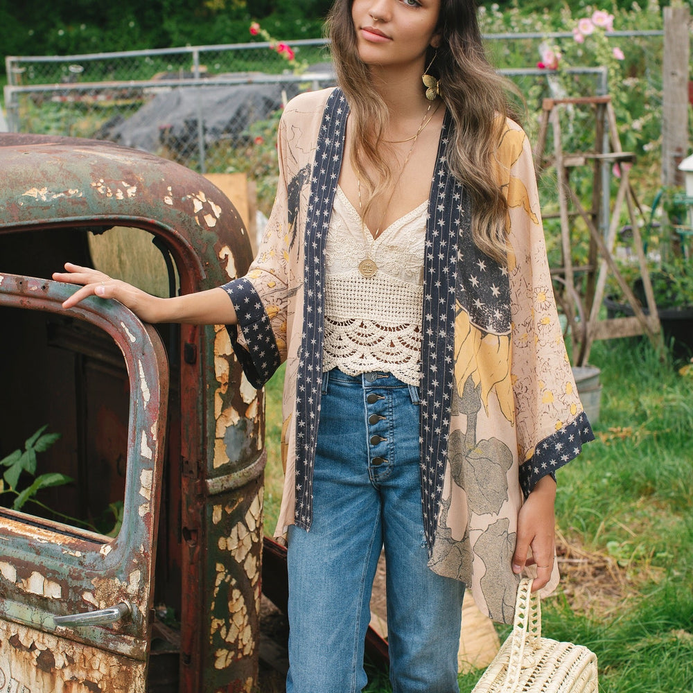 
                  
                    Model wearing our matinee length kimono featuring vintage-inspired Milk & Honey print with 1904 typography and floral woodcuts – Market of Stars
                  
                