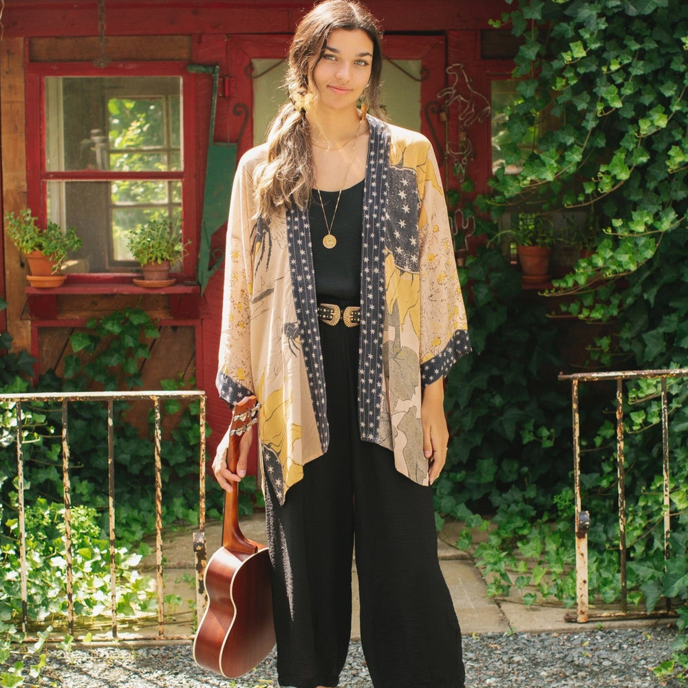 
                  
                    Model wearing our matinee length kimono featuring vintage-inspired Milk & Honey print with 1904 typography and floral woodcuts – Market of Stars
                  
                