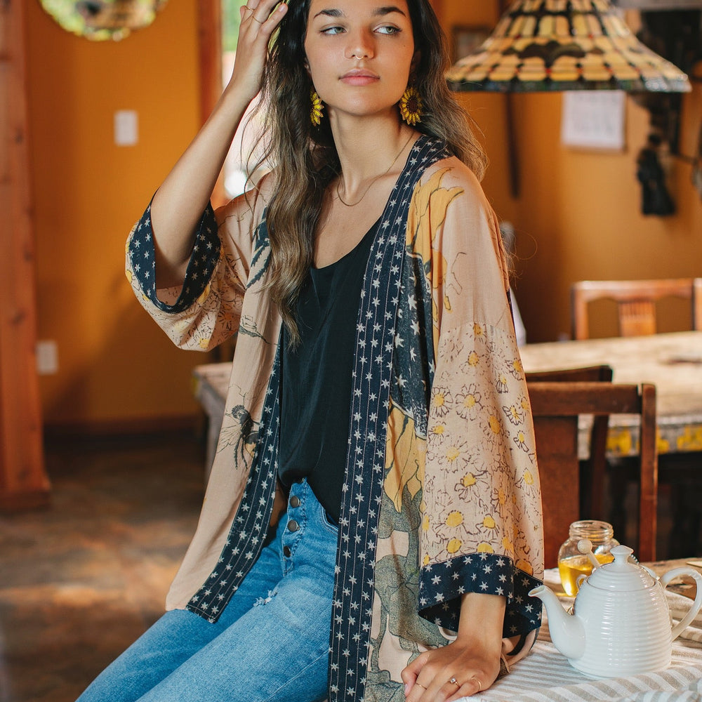 
                  
                    Model wearing our matinee length kimono featuring vintage-inspired Milk & Honey print with 1904 typography and floral woodcuts – Market of Stars
                  
                