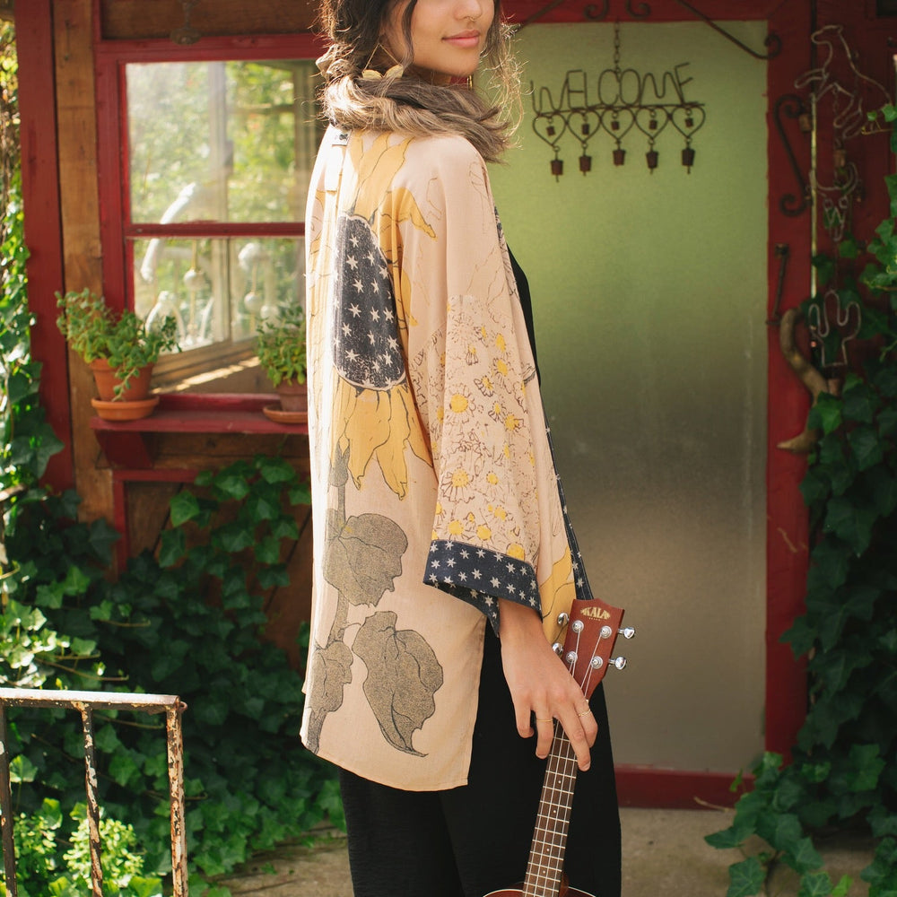 
                  
                    Model wearing our matinee length kimono featuring vintage-inspired Milk & Honey print with 1904 typography and floral woodcuts – Market of Stars
                  
                