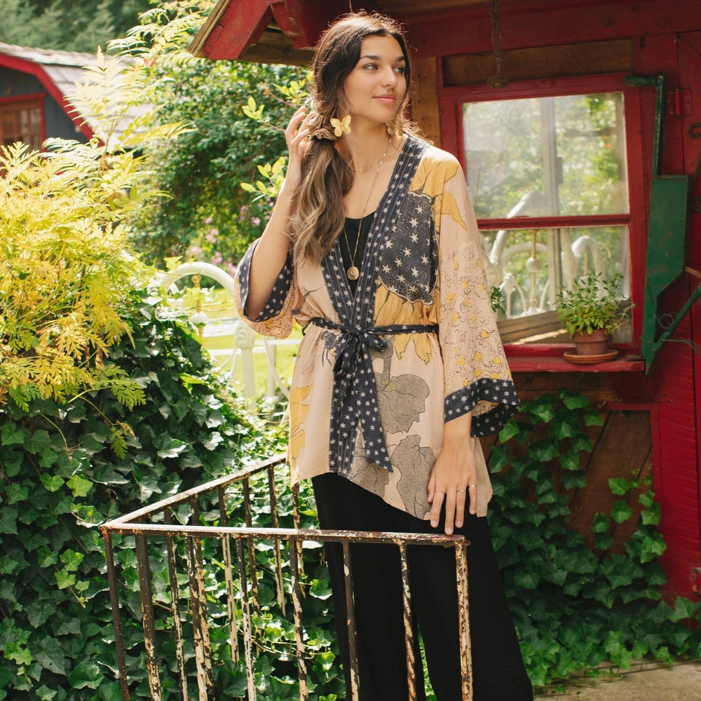 
                  
                    Model wearing our matinee length kimono featuring vintage-inspired Milk & Honey print with 1904 typography and floral woodcuts – Market of Stars
                  
                