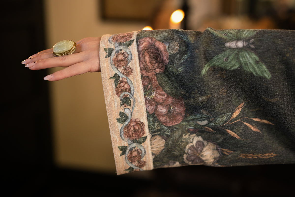 Model wearing a cozy fleece lined cottage cardigan ft. artwork created by Jessica Roux including two starlings beneath a full moon with flowers, butterflies, moths and botanical artwork - Market of Stars