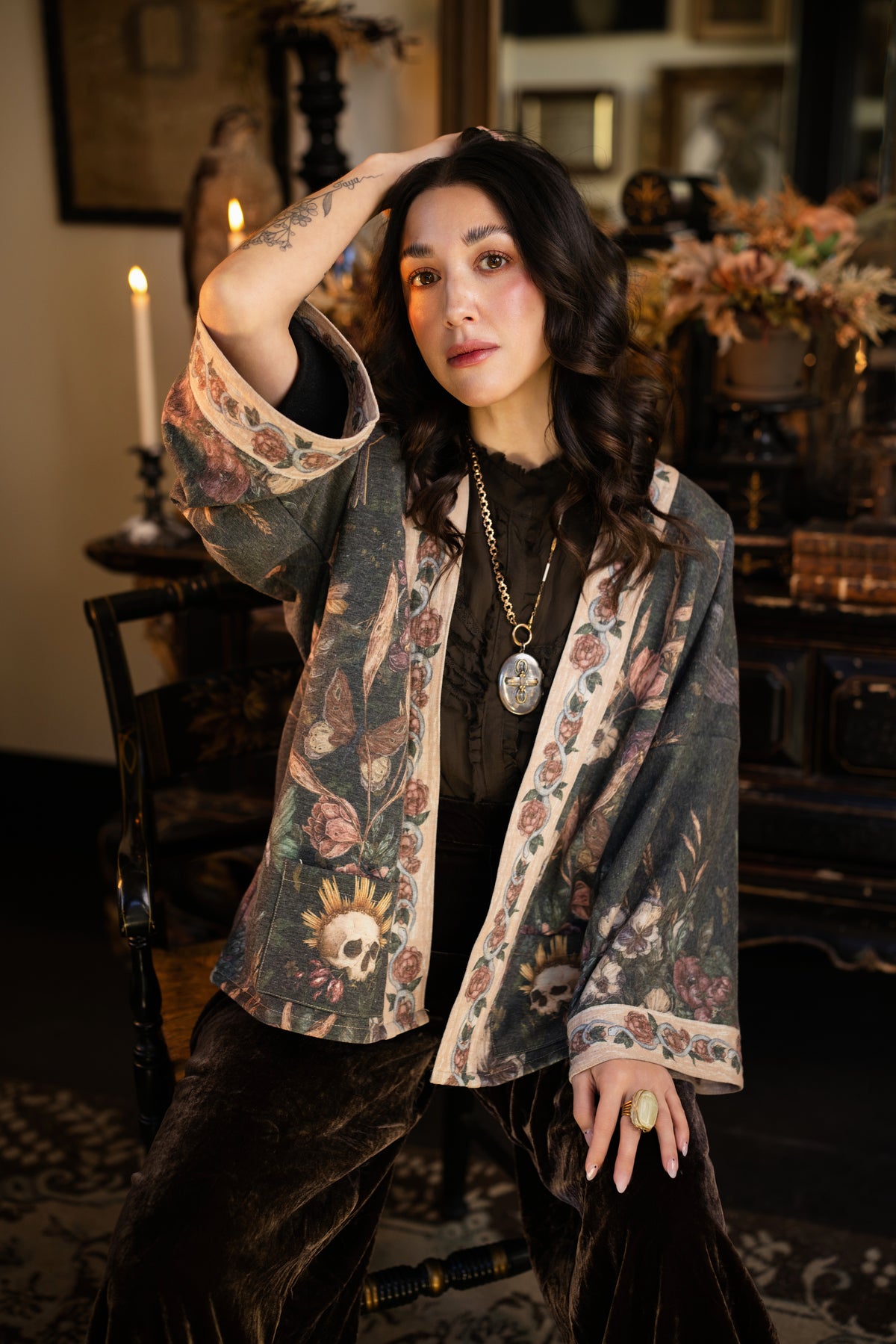 Model wearing a cozy fleece lined cottage cardigan ft. artwork created by Jessica Roux including two starlings beneath a full moon with flowers, butterflies, moths and botanical artwork - Market of Stars