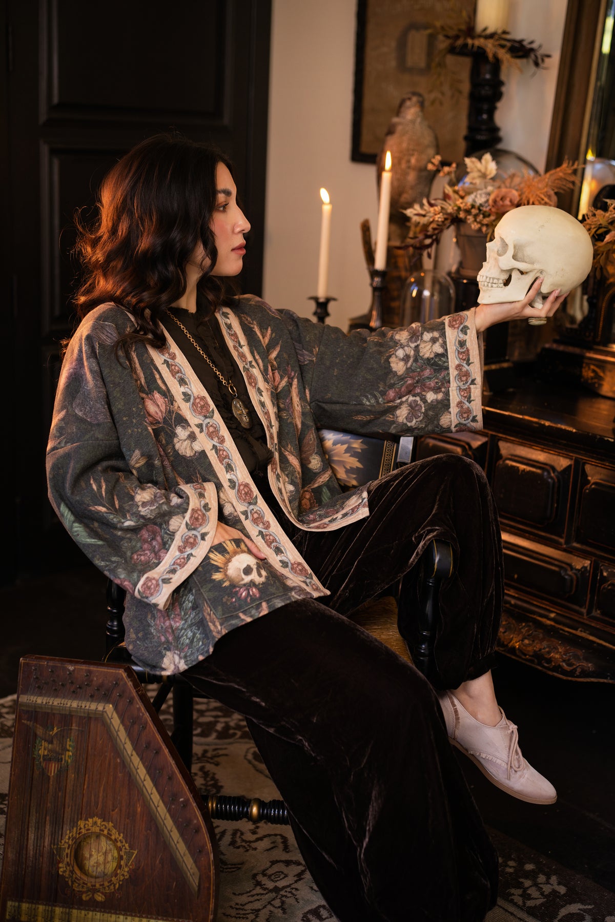 Model wearing a cozy fleece lined cottage cardigan ft. artwork created by Jessica Roux including two starlings beneath a full moon with flowers, butterflies, moths and botanical artwork - Market of Stars