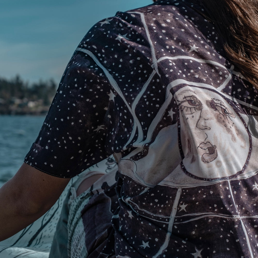 
                  
                    Model wearing Moonstruck Goddess Duster featuring original artwork by Leslie Love, inspired by the ocean, the night sky, and the artist’s handmade botanical inks – Market of Stars.
                  
                