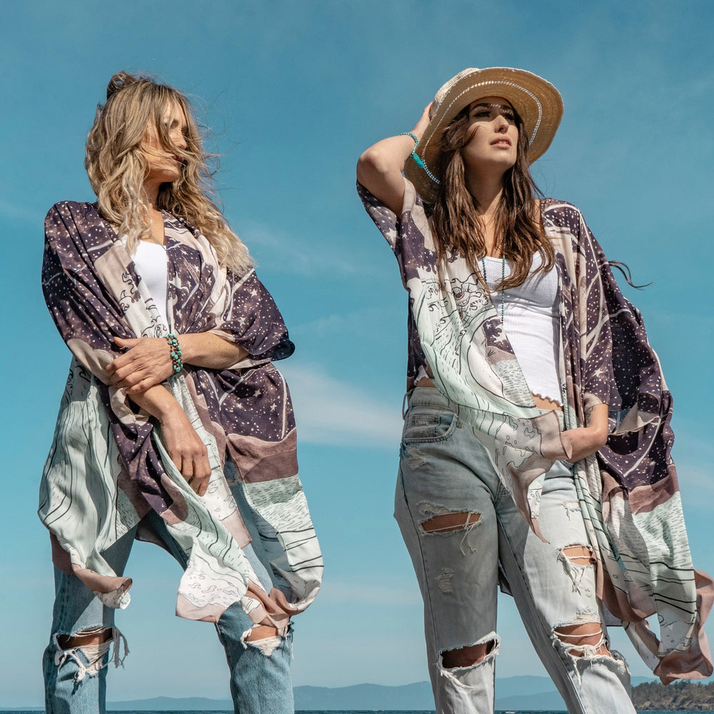 
                  
                    Model wearing Moonstruck Goddess Duster featuring original artwork by Leslie Love, inspired by the ocean, the night sky, and the artist’s handmade botanical inks – Market of Stars.
                  
                