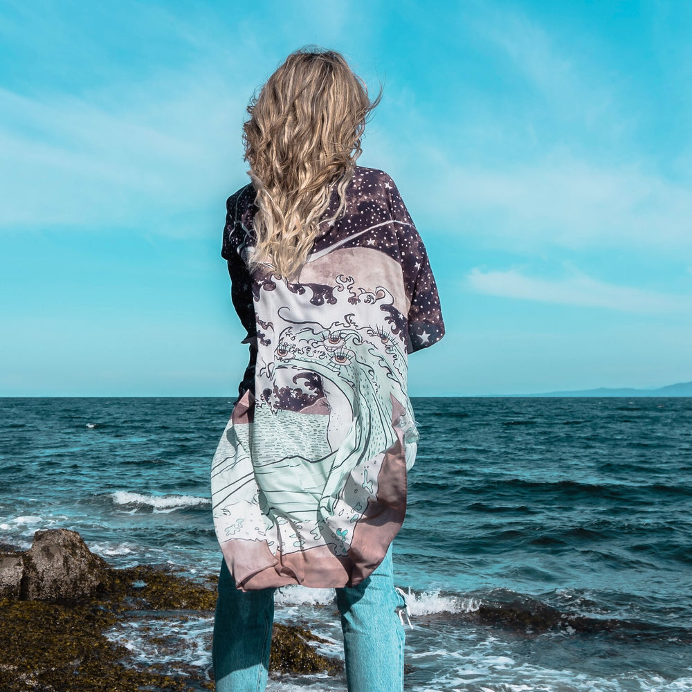 
                  
                    Model wearing Moonstruck Goddess Duster featuring original artwork by Leslie Love, inspired by the ocean, the night sky, and the artist’s handmade botanical inks – Market of Stars.
                  
                