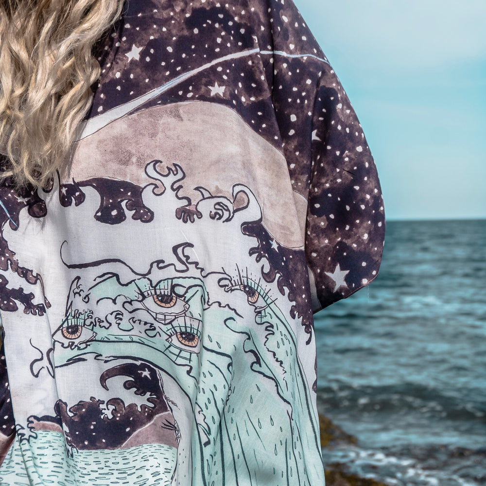 
                  
                    Model wearing Moonstruck Goddess Duster featuring original artwork by Leslie Love, inspired by the ocean, the night sky, and the artist’s handmade botanical inks – Market of Stars.
                  
                