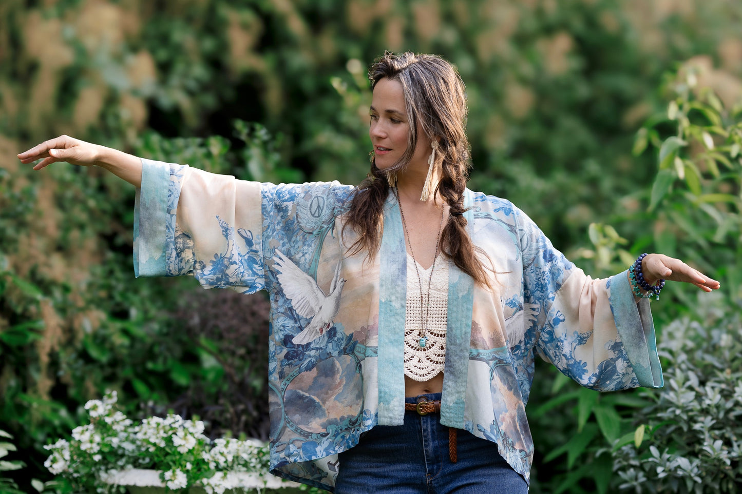 Model wearing our Peace Out Pixie Duster featuring 1800's perfumeur sign with gentle tones of blue & aqua, landscapes, clouds, dove and peace symbols -Market of Stars.