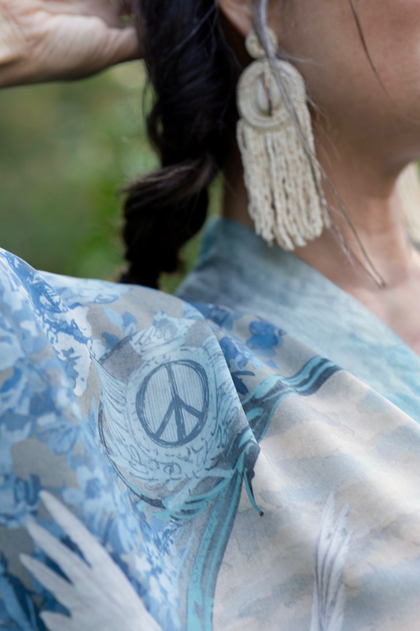 Model wearing our Peace Out Pixie Duster featuring 1800's perfumeur sign with gentle tones of blue & aqua, landscapes, clouds, dove and peace symbols -Market of Stars.