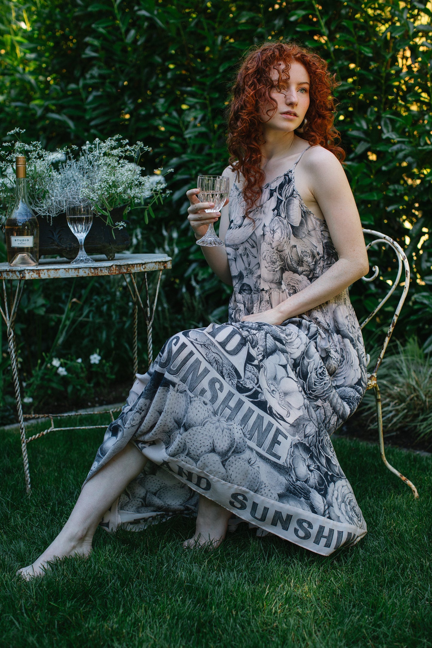 Model wearing Peace, Wine & Sunshine Bohéme Slip Dress featuring botanical collages and playful peace, wine and sunshine lettering on the hem – Market of Stars.