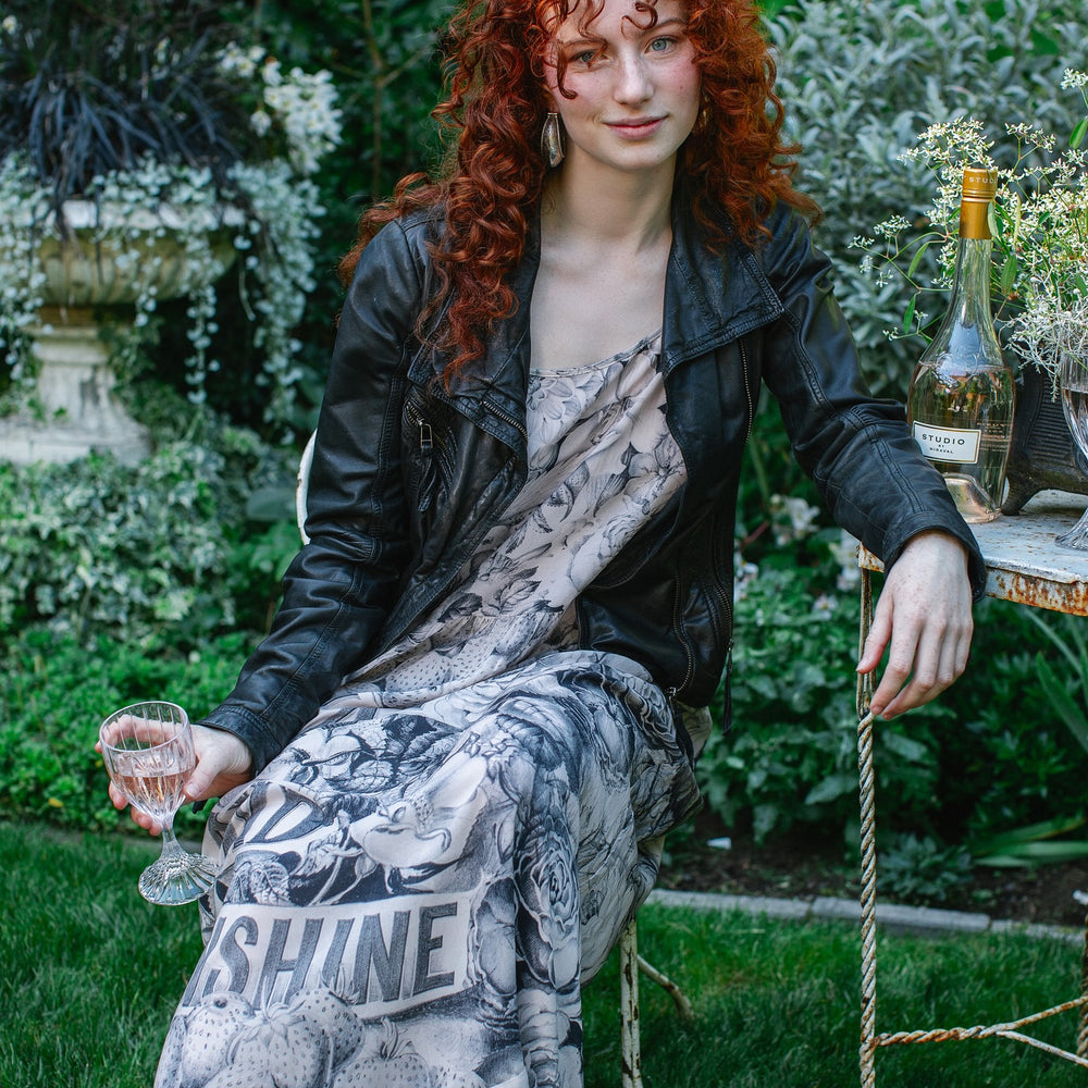 
                  
                    Model wearing Peace, Wine & Sunshine Bohéme Slip Dress featuring botanical collages and playful peace, wine and sunshine lettering on the hem – Market of Stars.
                  
                