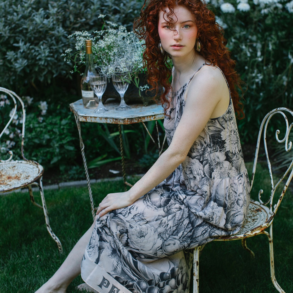 
                  
                    Model wearing Peace, Wine & Sunshine Bohéme Slip Dress featuring botanical collages and playful peace, wine and sunshine lettering on the hem – Market of Stars.
                  
                