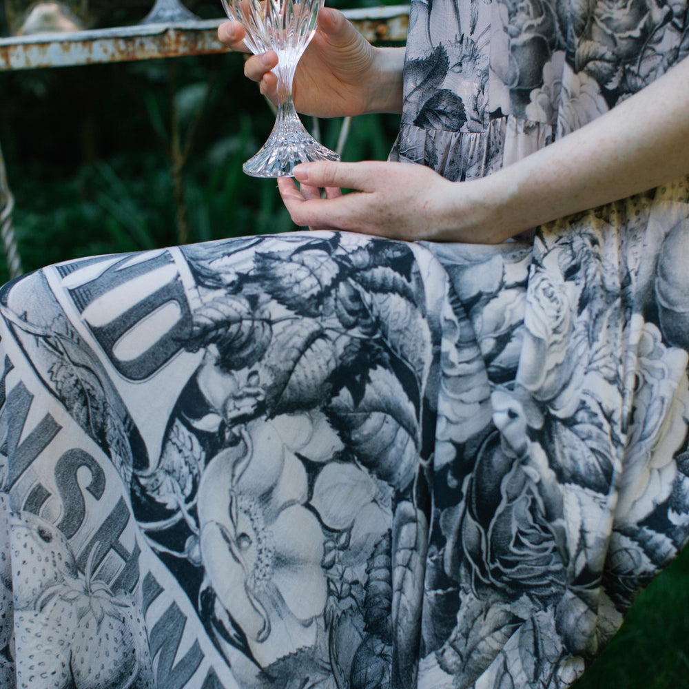 
                  
                    Model wearing Peace, Wine & Sunshine Bohéme Slip Dress featuring botanical collages and playful peace, wine and sunshine lettering on the hem – Market of Stars.
                  
                