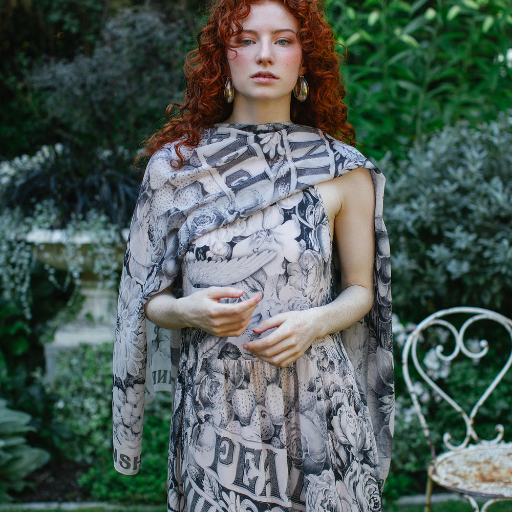 
                  
                    Model wearing Peace, Wine & Sunshine Bohéme Slip Dress featuring botanical collages and playful peace, wine and sunshine lettering on the hem – Market of Stars.
                  
                