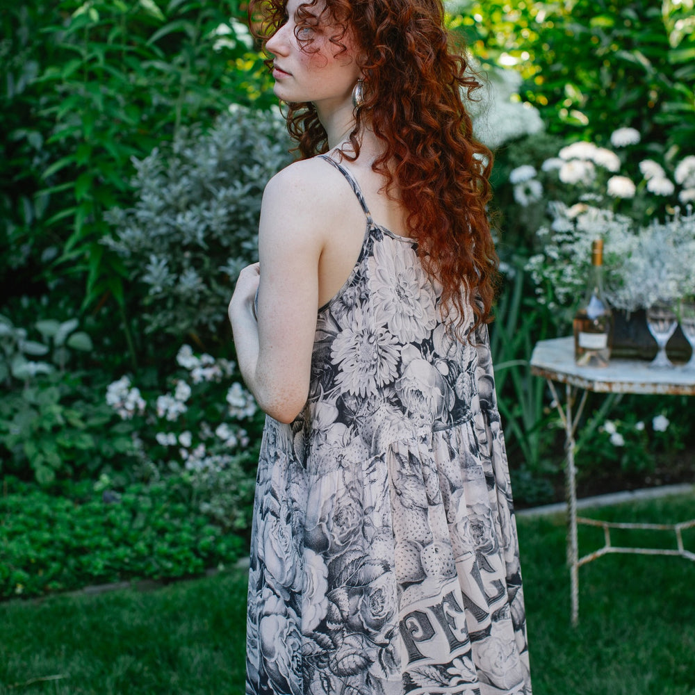 
                  
                    Model wearing Peace, Wine & Sunshine Bohéme Slip Dress featuring botanical collages and playful peace, wine and sunshine lettering on the hem – Market of Stars.
                  
                