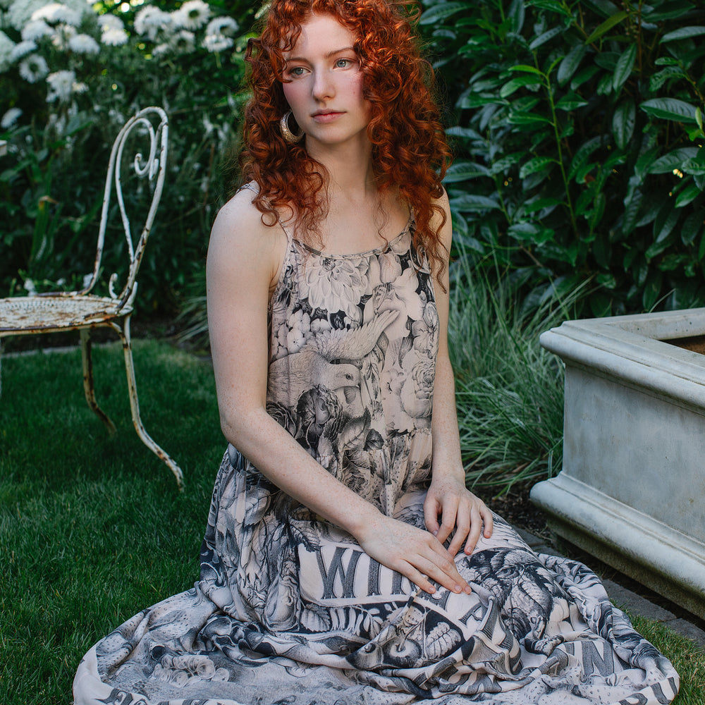 
                  
                    Model wearing Peace, Wine & Sunshine Bohéme Slip Dress featuring botanical collages and playful peace, wine and sunshine lettering on the hem – Market of Stars.
                  
                