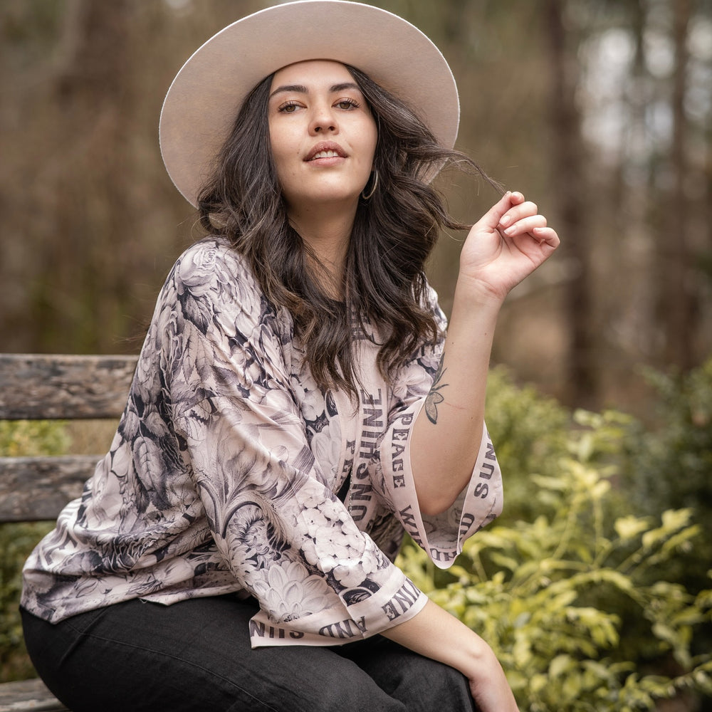 
                  
                    Model wearing Peace, Wine & Sunshine Bohéme Slip Dress featuring botanical collages and playful peace, wine and sunshine lettering on the hem – Market of Stars.
                  
                