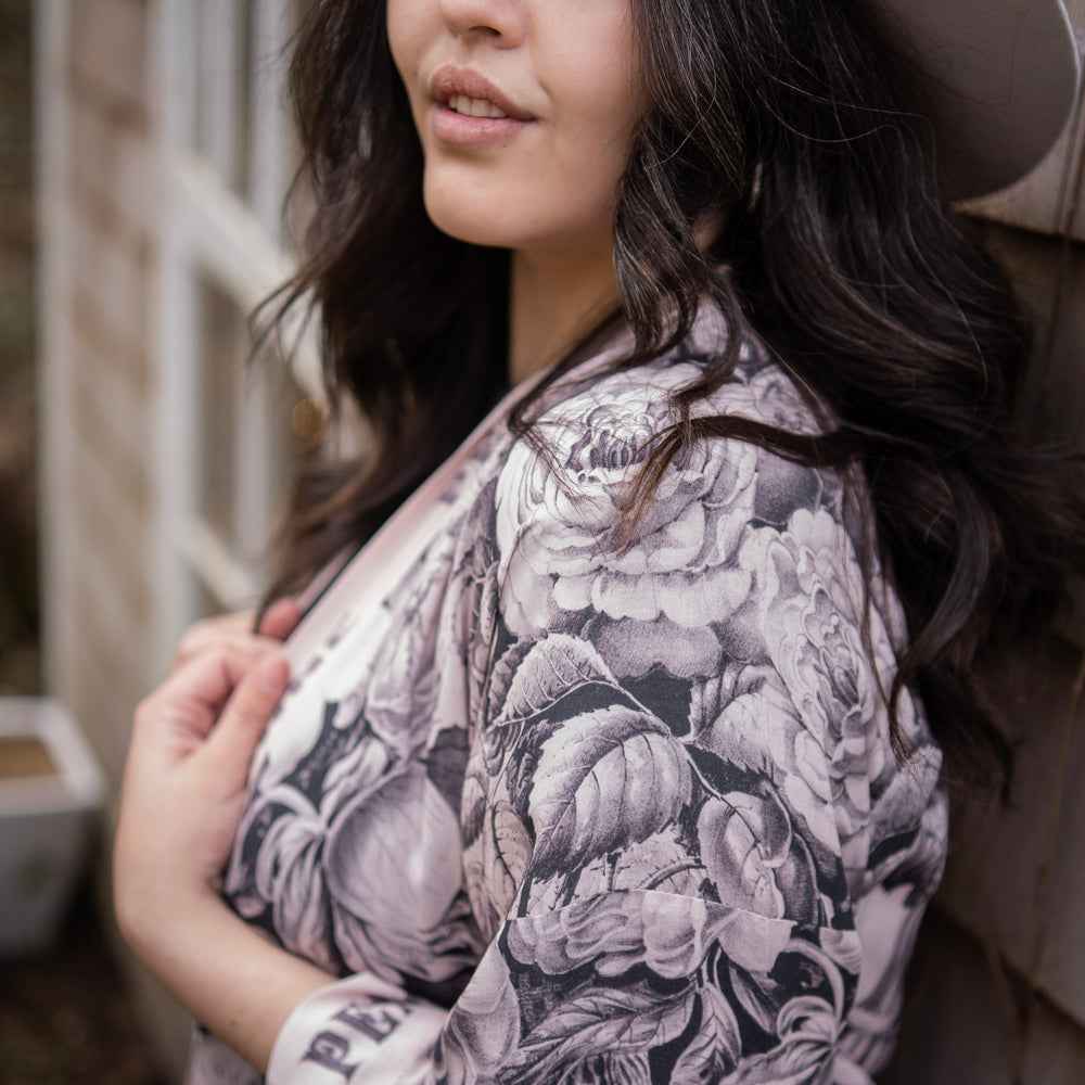 
                  
                    Model wearing Peace, Wine & Sunshine Bohéme Slip Dress featuring botanical collages and playful peace, wine and sunshine lettering on the hem – Market of Stars.
                  
                