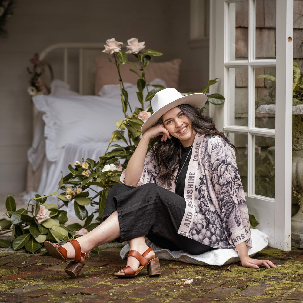 
                  
                    Model wearing Peace, Wine & Sunshine Bohéme Slip Dress featuring botanical collages and playful peace, wine and sunshine lettering on the hem – Market of Stars.
                  
                