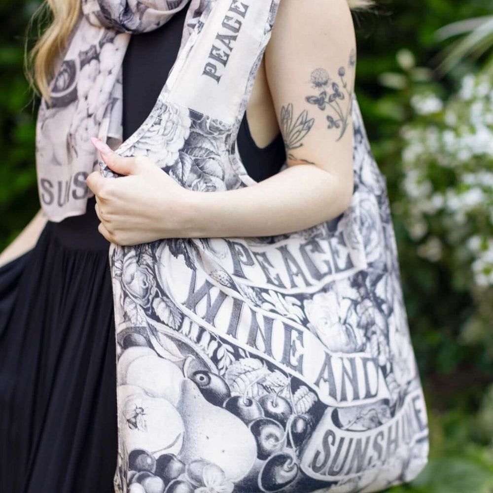 Model wearing a linen tote bag for everyday adventures with a whimsical print celebrating life's simple pleasures - Market of Stars