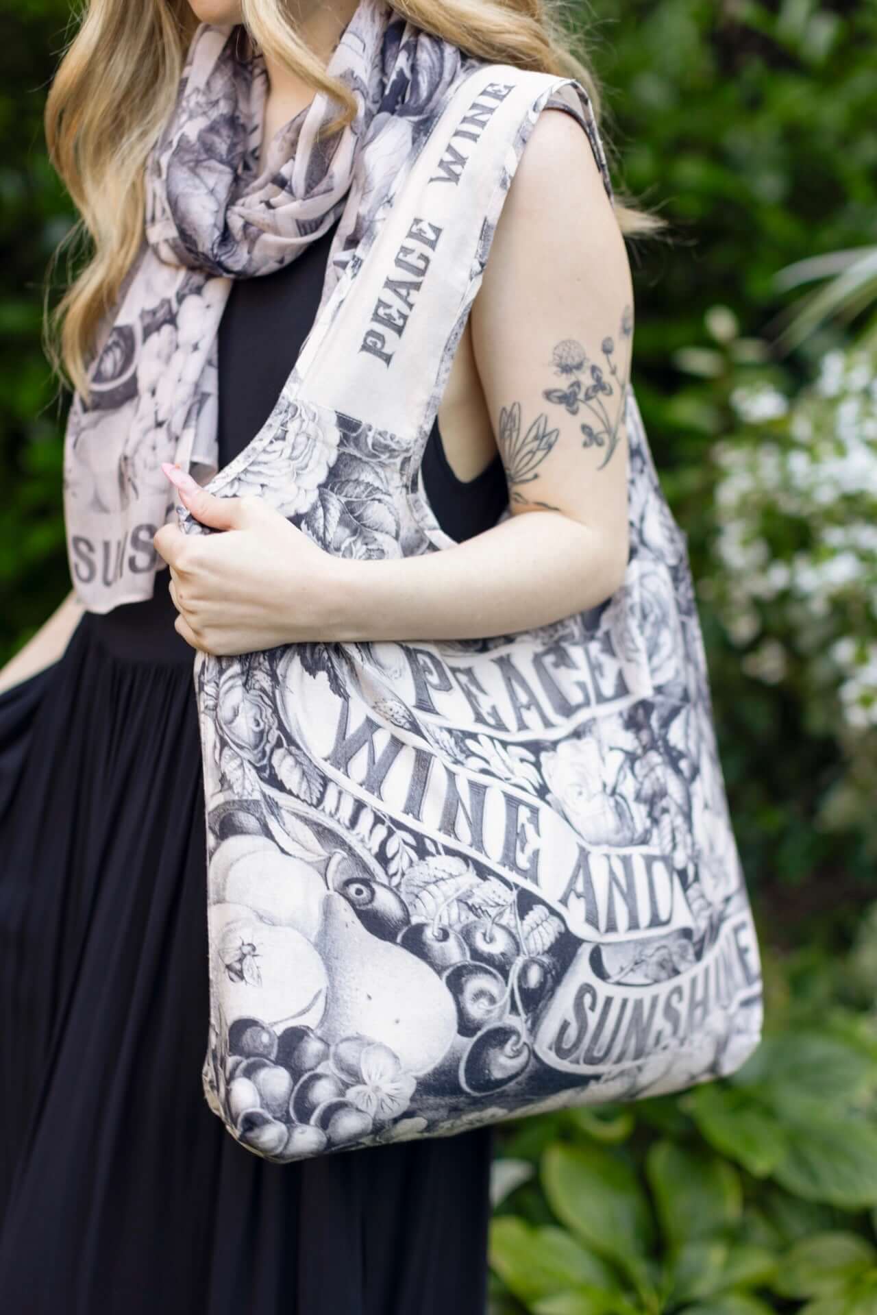 Model wearing a linen tote bag for everyday adventures with a whimsical print celebrating life's simple pleasures - Market of Stars