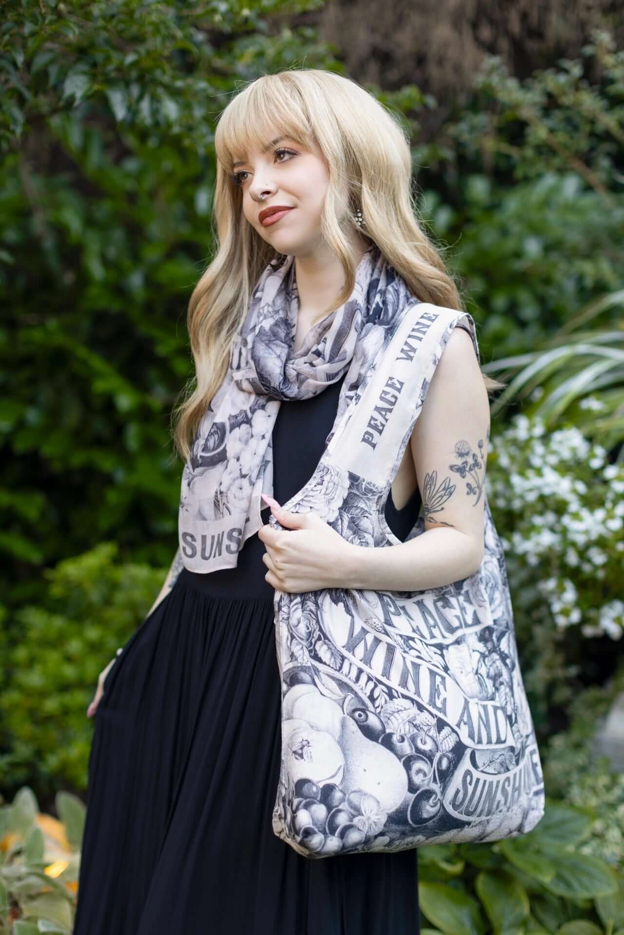 Model wearing a linen tote bag for everyday adventures with a whimsical print celebrating life's simple pleasures - Market of Stars