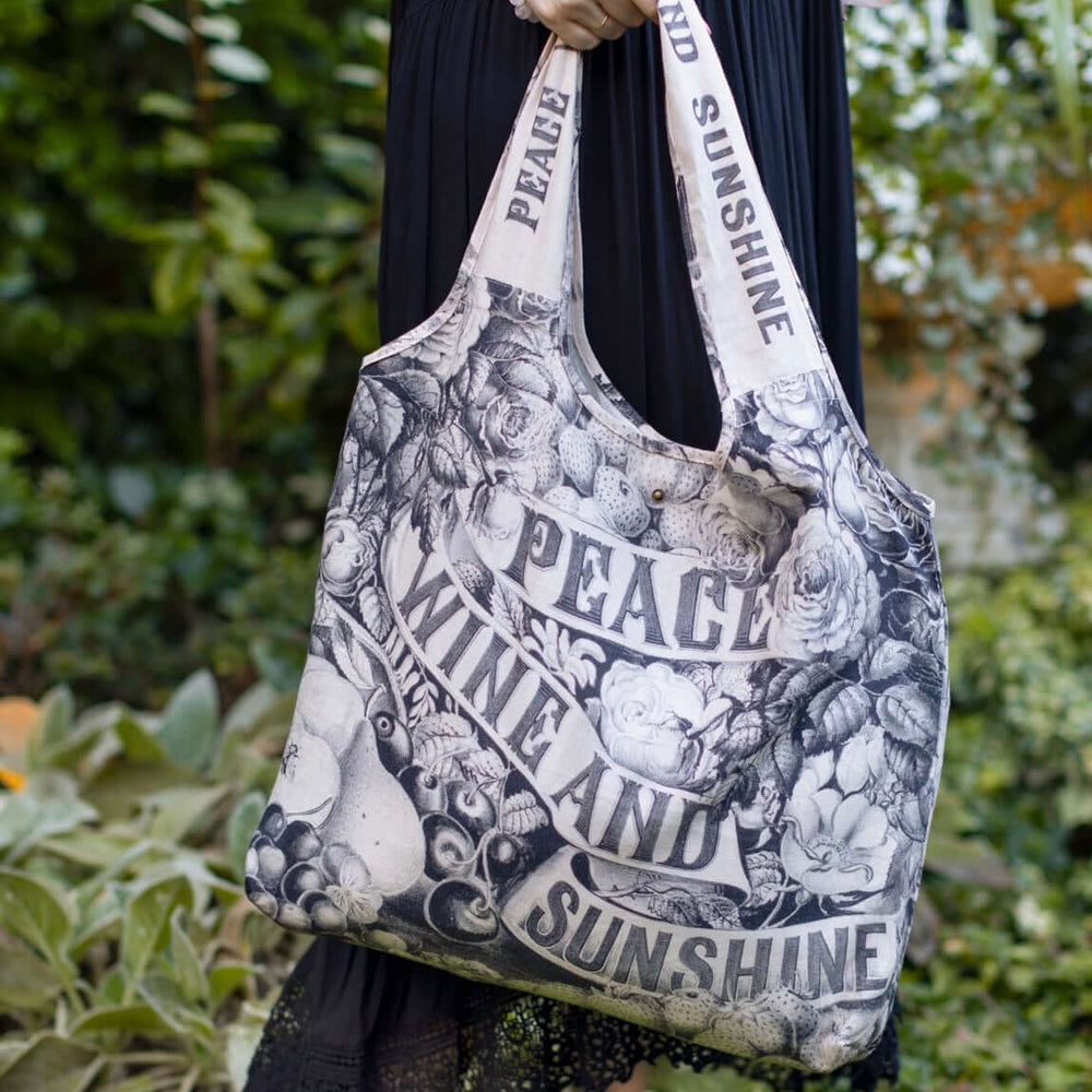 
                  
                    Model wearing a linen tote bag for everyday adventures with a whimsical print celebrating life's simple pleasures - Market of Stars
                  
                