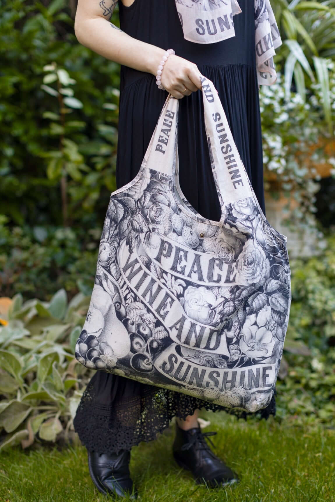 Model wearing a linen tote bag for everyday adventures with a whimsical print celebrating life's simple pleasures - Market of Stars