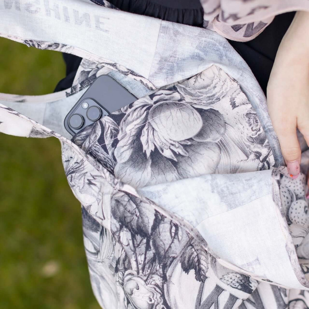 
                  
                    Model wearing a linen tote bag for everyday adventures with a whimsical print celebrating life's simple pleasures - Market of Stars
                  
                