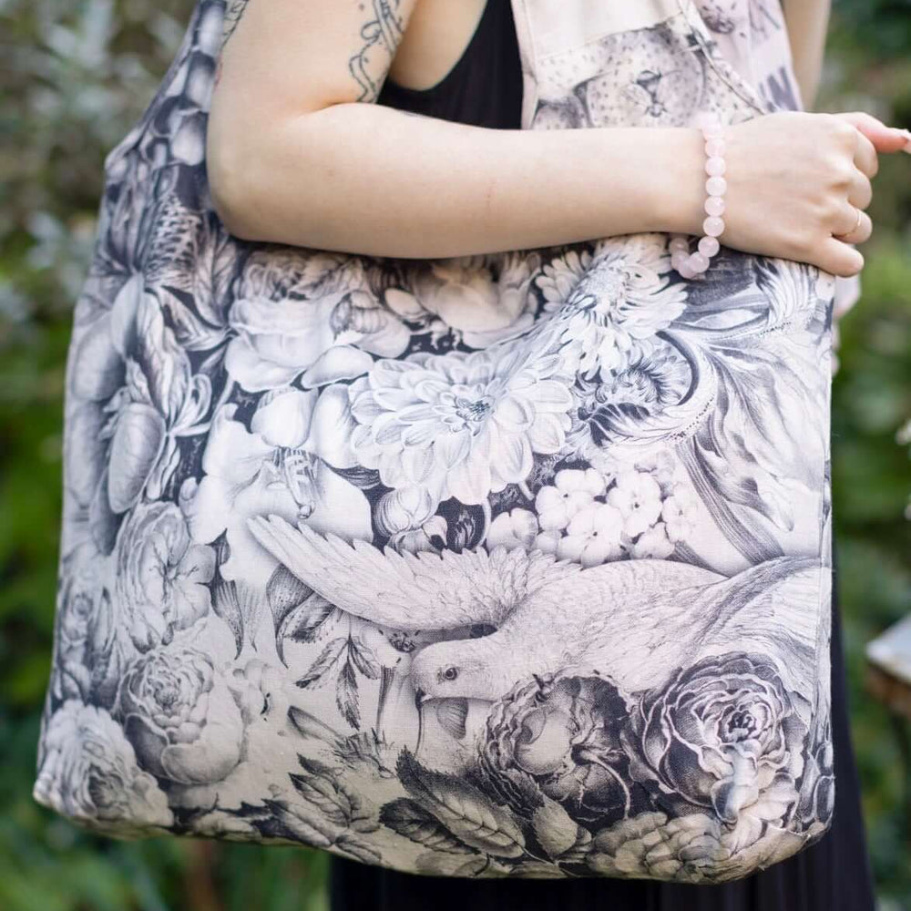 
                  
                    Model wearing a linen tote bag for everyday adventures with a whimsical print celebrating life's simple pleasures - Market of Stars
                  
                