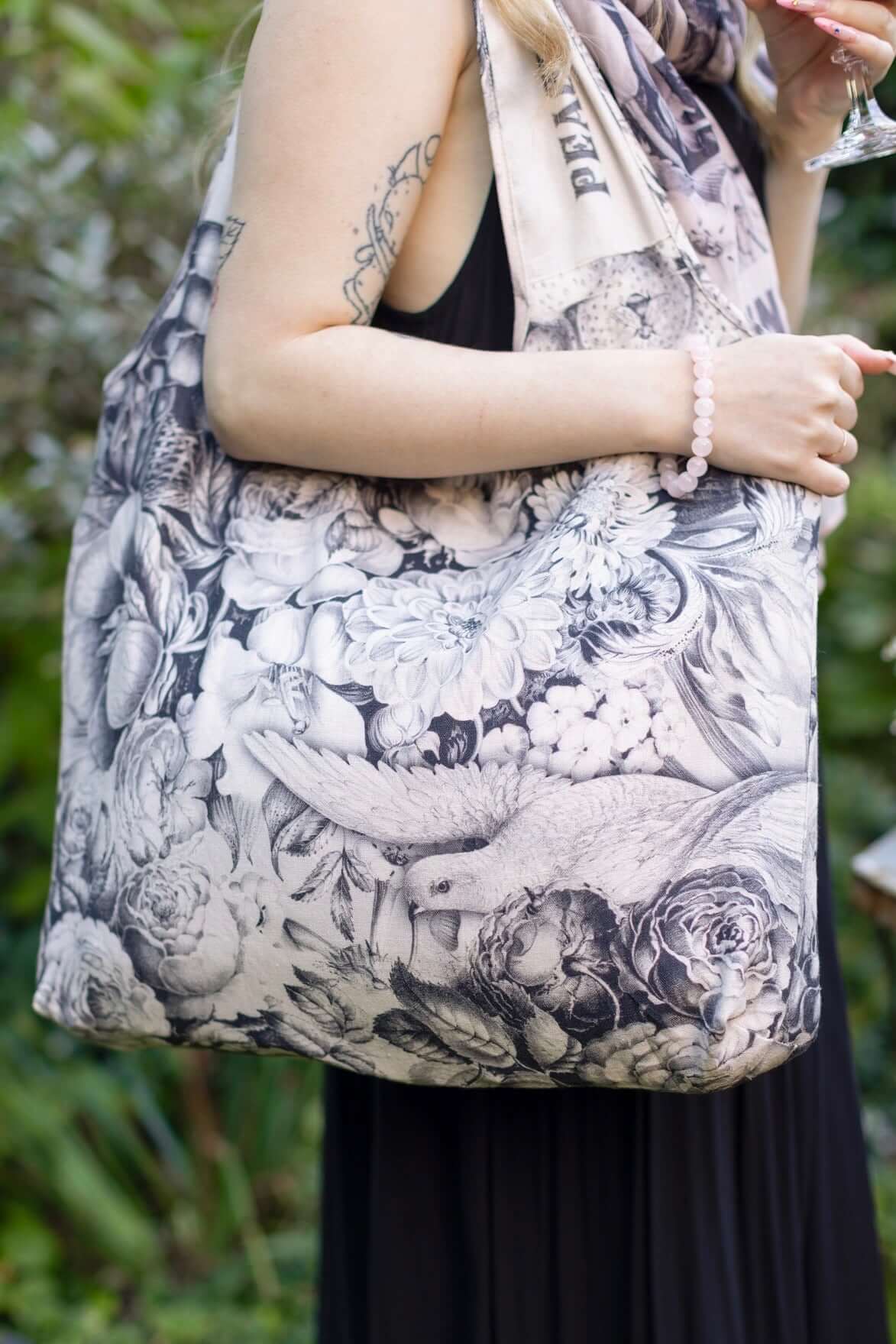 Model wearing a linen tote bag for everyday adventures with a whimsical print celebrating life's simple pleasures - Market of Stars