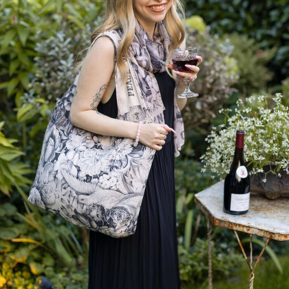 
                  
                    Model wearing a linen tote bag for everyday adventures with a whimsical print celebrating life's simple pleasures - Market of Stars
                  
                