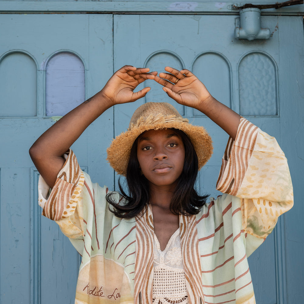 
                  
                    Model wearing Peace, Wine & Sunshine Bohéme Slip Dress featuring botanical collages and playful peace, wine and sunshine lettering on the hem – Market of Stars.
                  
                