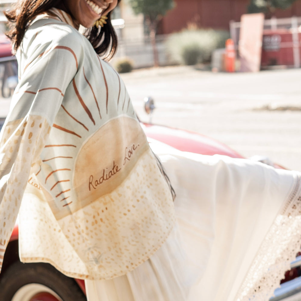 
                  
                    Model wearing Peace, Wine & Sunshine Bohéme Slip Dress featuring botanical collages and playful peace, wine and sunshine lettering on the hem – Market of Stars.
                  
                