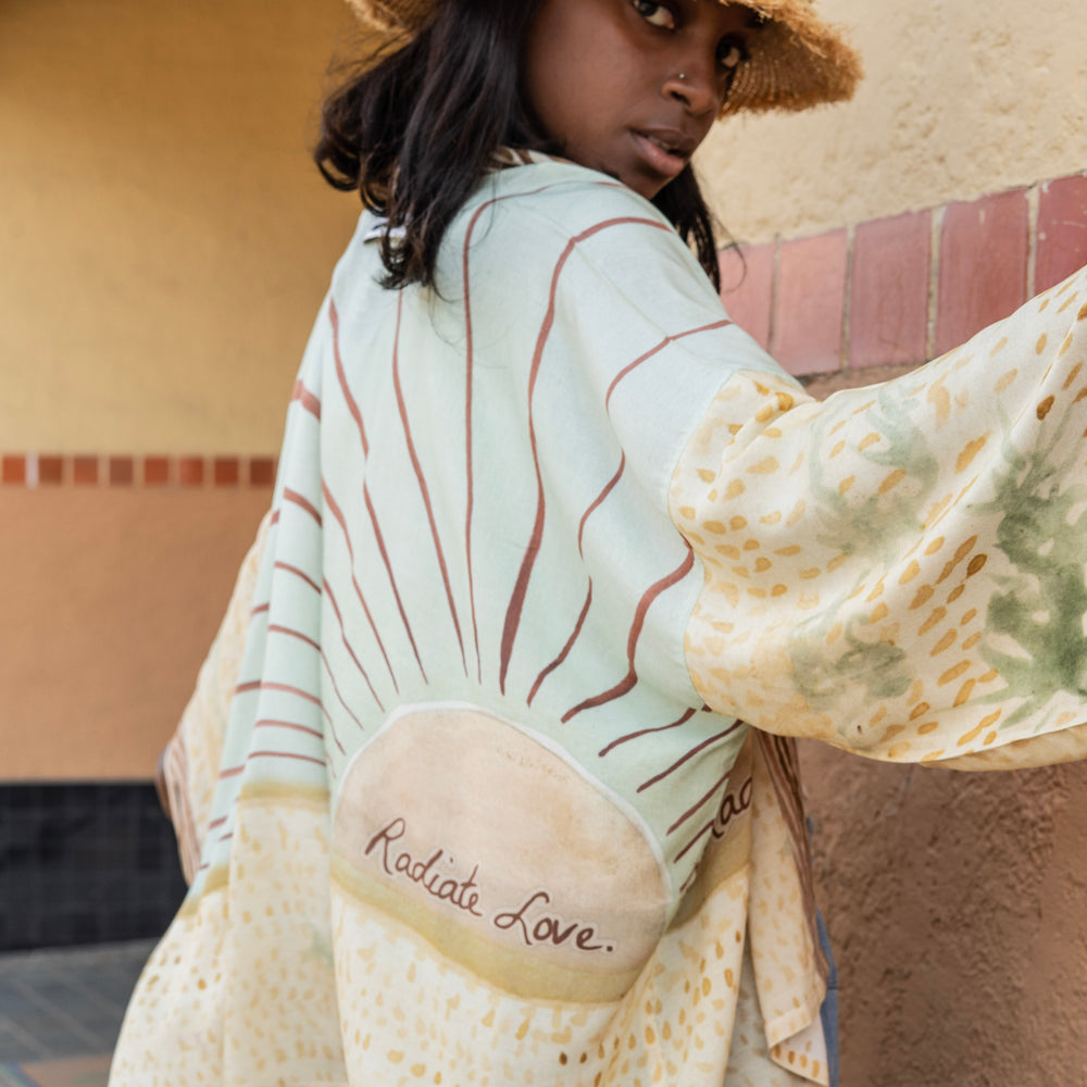 
                  
                    Model wearing Peace, Wine & Sunshine Bohéme Slip Dress featuring botanical collages and playful peace, wine and sunshine lettering on the hem – Market of Stars.
                  
                