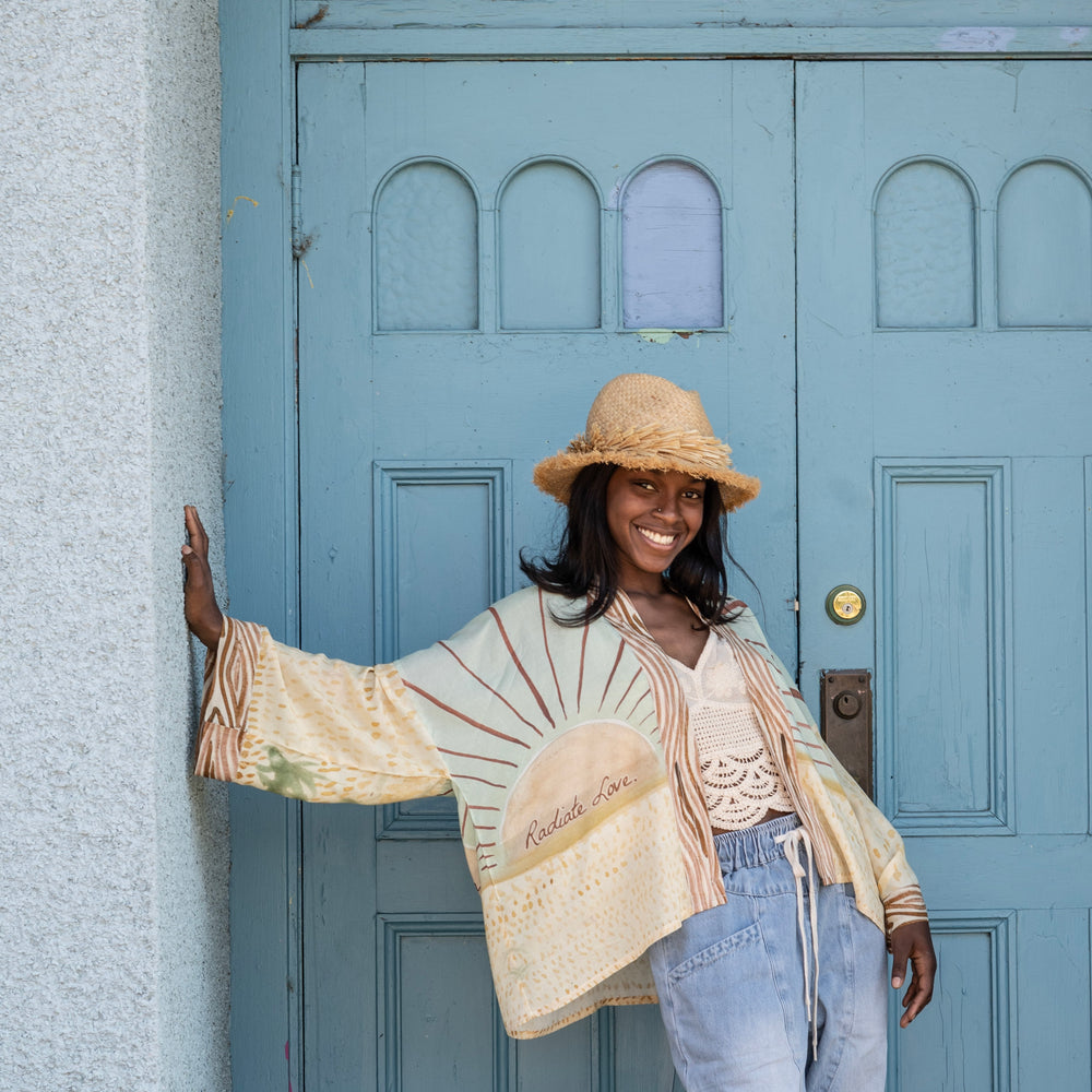 
                  
                    Model wearing Peace, Wine & Sunshine Bohéme Slip Dress featuring botanical collages and playful peace, wine and sunshine lettering on the hem – Market of Stars.
                  
                