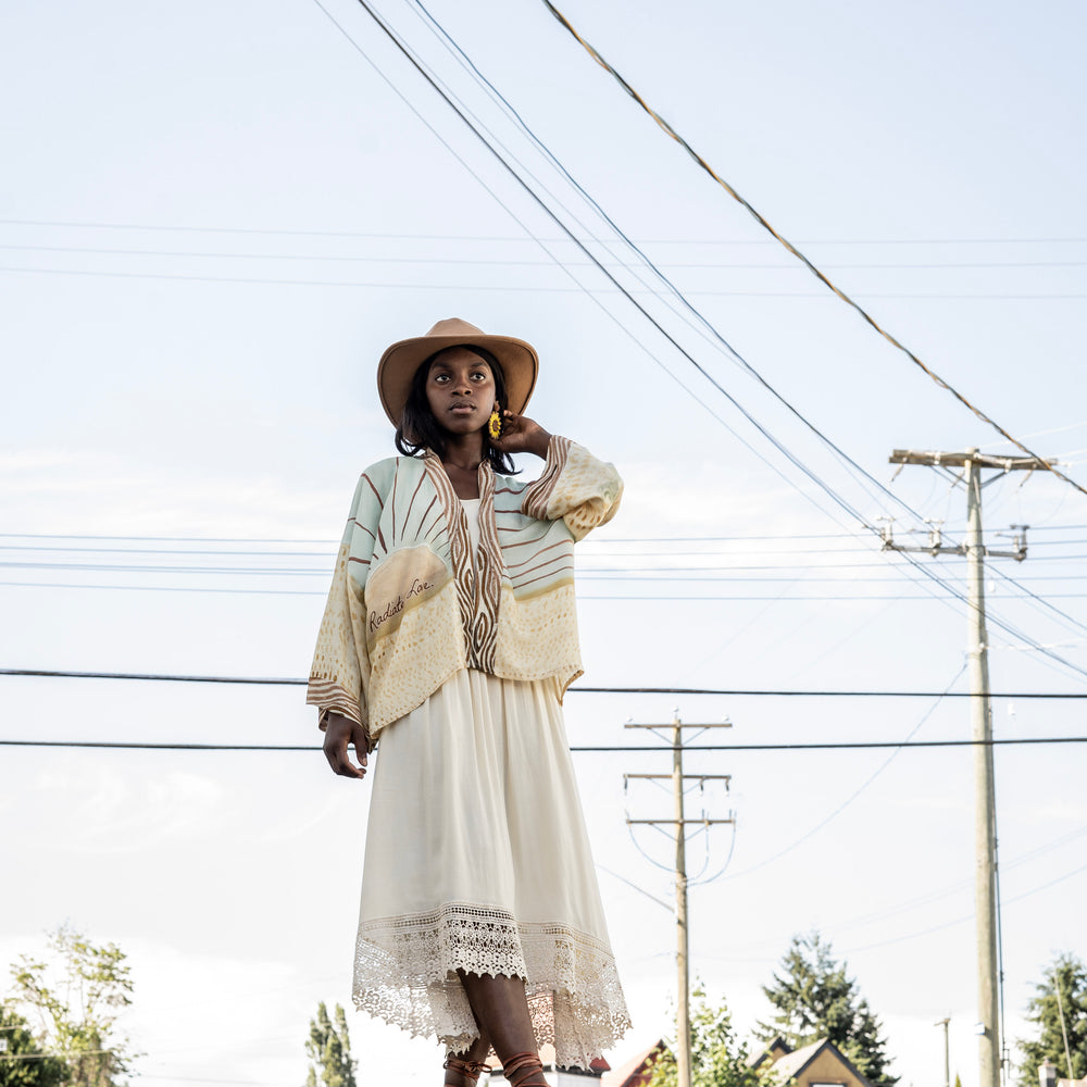 
                  
                    Model wearing Peace, Wine & Sunshine Bohéme Slip Dress featuring botanical collages and playful peace, wine and sunshine lettering on the hem – Market of Stars.
                  
                