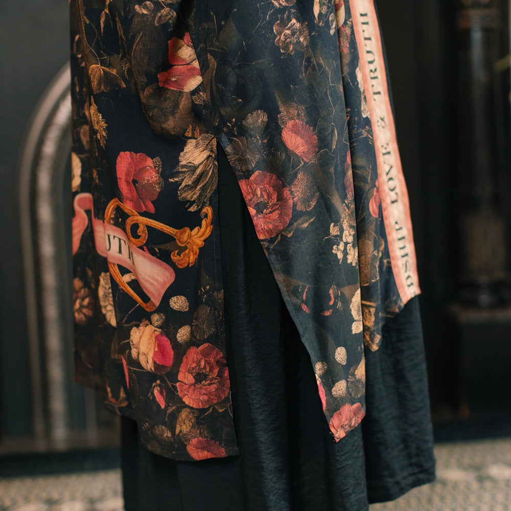
                  
                    Model wearing a full-length bamboo-viscose duster featuring a collage of antique artwork with romance, loyalty, and old-world beauty - Market of Stars
                  
                