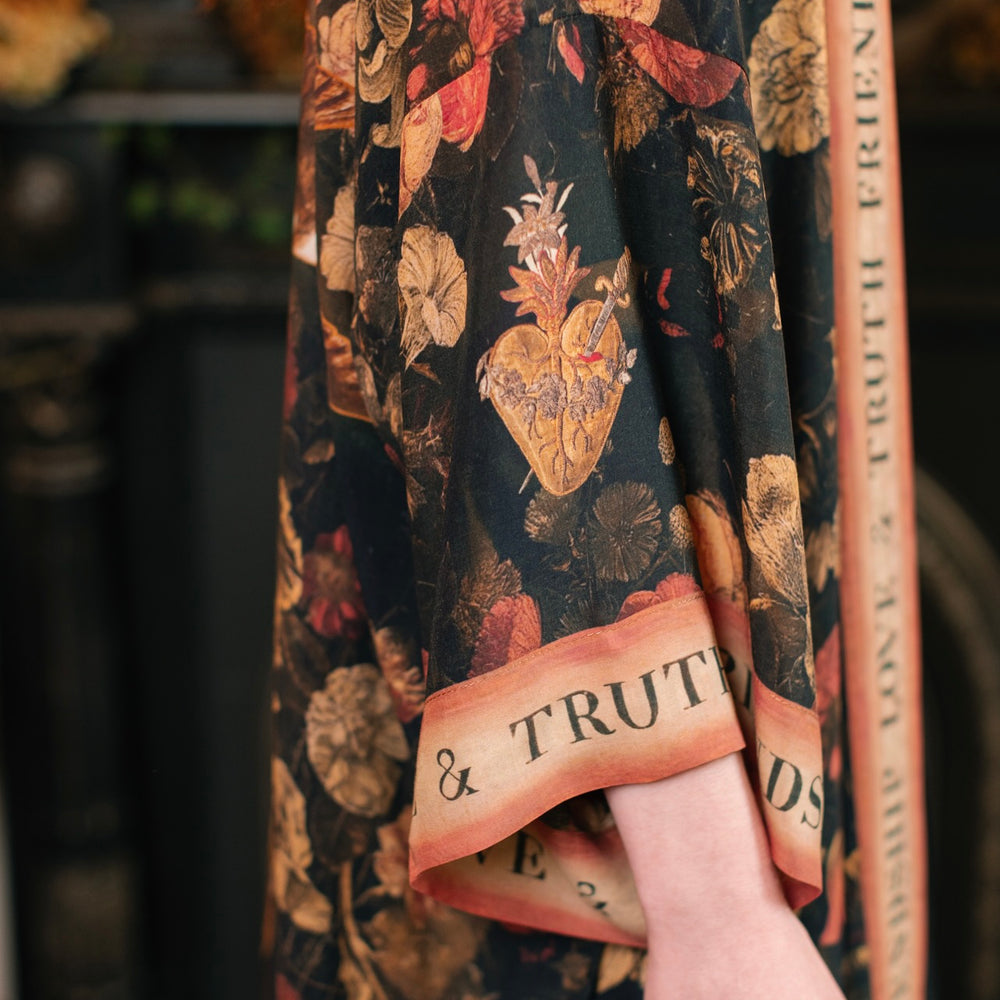 
                  
                    Model wearing a full-length bamboo-viscose duster featuring a collage of antique artwork with romance, loyalty, and old-world beauty - Market of Stars
                  
                