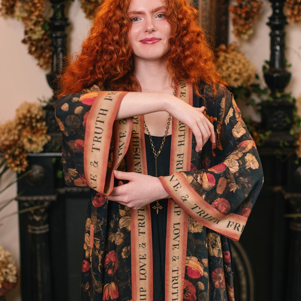 
                  
                    Model wearing a full-length bamboo-viscose duster featuring a collage of antique artwork with romance, loyalty, and old-world beauty - Market of Stars
                  
                